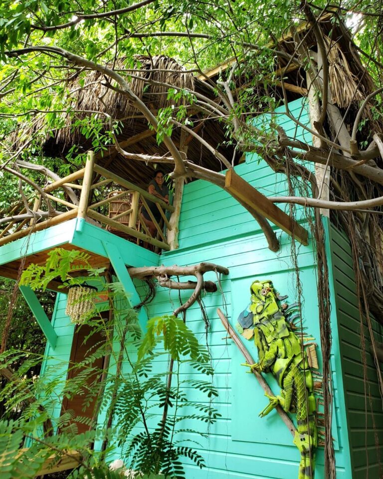 A turquoise wooden palapa among the trees in the garden at Mondi Lodge, Curaçao